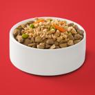 Fresh Purina ONE dog food entrée placed over dry kibble in a white bowl.