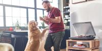 man dancing with golden retriever dog