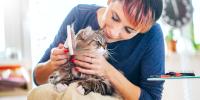 Una dama cepillando suavemente a un gato de pelo largo