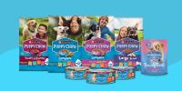 A variety of Purina Puppy Chow dry food, wet food, and training treats sit on a blue swirled background