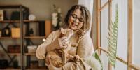 person holding cat in front of window