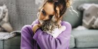 A person hugging their cat.