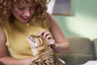 woman looking down at cat that is looking up at her