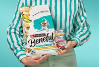 Person holding a bag of incredibites dog food kibble and three cans of wet incredibites.