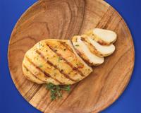 Plated sliced and seasoned chicken breast sits on a blue background