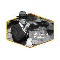 Una foto en blanco y negro de William H. Danforth sosteniendo una bolsa de Purina Chow