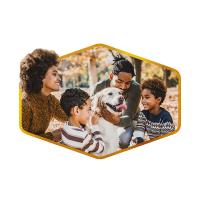 An image of a family of four smiling and petting a golden retriever in an outdoor autumn setting