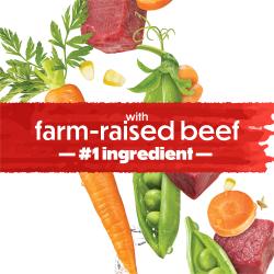 Un banner rojo con efecto de salpicadura muestra el texto que dice "con carne de res criada en granja como ingrediente #1." Zanahorias, chícharos y carne de res adornan el fondo.