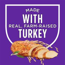 Un escudo se encuentra sobre un fondo morado con texto que dice "hecho con pavo real, criado en granja." Una foto de pechuga de pavo en rebanadas con hierbas y granos se encuentra debajo del escudo
