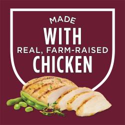 Un escudo se encuentra sobre un fondo color vino con texto que dice “hecho con pollo real, criado en granja”. Una foto de pechuga de pollo en rebanadas con hierbas y vainas de soya se encuentra debajo del escudo