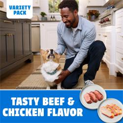 Man feeding a variety pack beef and chicken Purina DentaLife Daily Oral Care dog treat to his Corgi.
