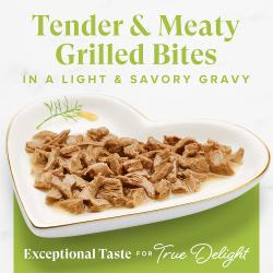 Close-up of tender meaty Fancy Feast Grilled Salmon wet cat food bites in light savory gravy served on a heart plate.