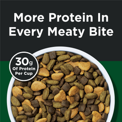 A bowl of kibble sits on a black and dark green background. Text about the kibble reads "More protein in every meaty bite." A circle badge left to the kibble reads "30g protein per cup"