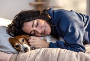 Woman snuggling small dog