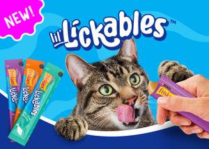 A cat excitedly licking its lips looking at a tube of new Friskies Lil’ Lickables.