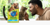 A bag of Cat Chow Naturals Indoor sits in the foreground of a photo of a man petting a grey cat