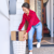 Person retrieving a cardboard package on a front porch outside a home