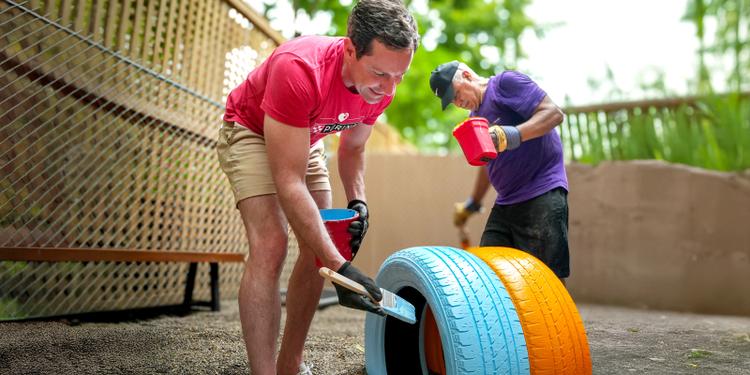 men painting tires at a shelter