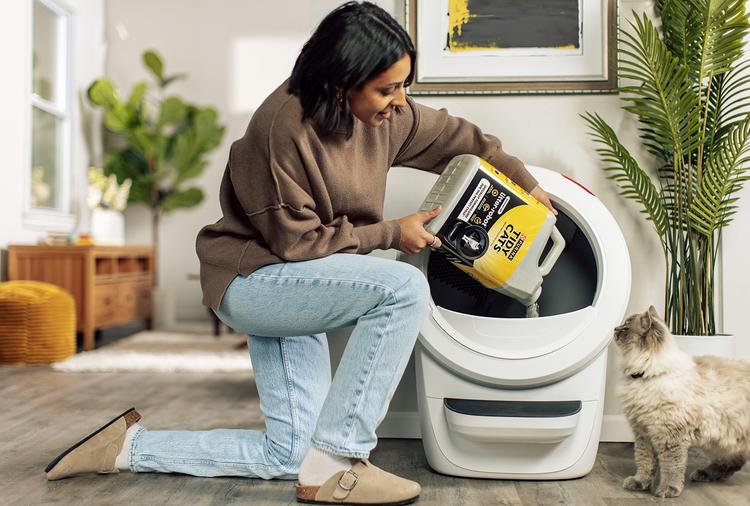 woman pouring Tidy Cat litter with cat