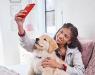 A human taking a selfie with their puppy.