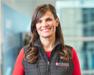 Alex in red shirt and black vest with Purina logo