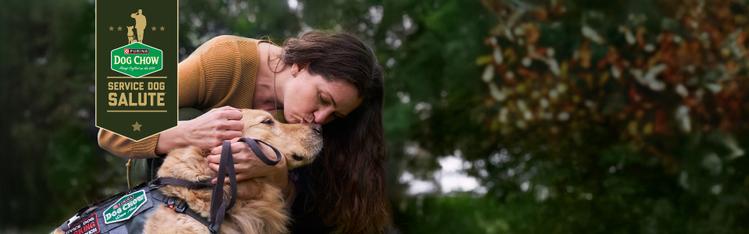 woman kissing dog on head