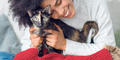 woman cuddling with her black and brown cat
