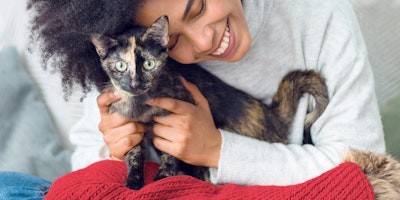 woman cuddling with her black and brown cat