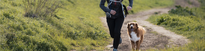 person running outside with their dog