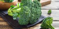 bunch of broccoli sitting on napkin on wooden table