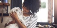 Una mujer sosteniendo a un gato
