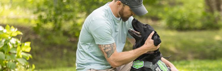 man petting black dog