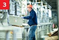 worker with hardhat inspecting bins