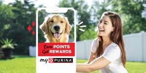 A woman smiling at her happy dog outlined by a phone promoting “Earn points, get rewards, myPurina”
