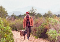 Man hiking with his dog beside him outdoors