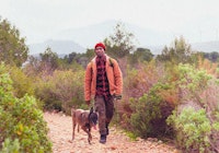 Man hiking with his dog beside him outdoors
