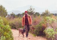 Man hiking with his dog beside him outdoors