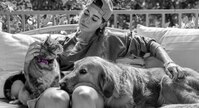 Woman petting a cat and a dog