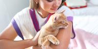 teenager petting orange cat