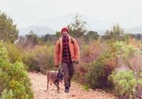 Man hiking with his dog beside him outdoors