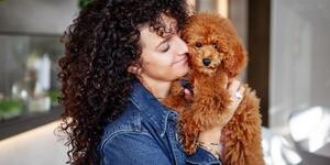 woman snuggling small dog