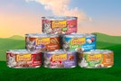 Friskies wet cat food on illustrated background of grassy hills