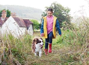 Una niña y un perro caminando