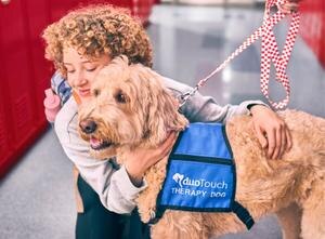 student hugging a duo dog