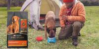 owner and dog camping with Pro Plan package to the side